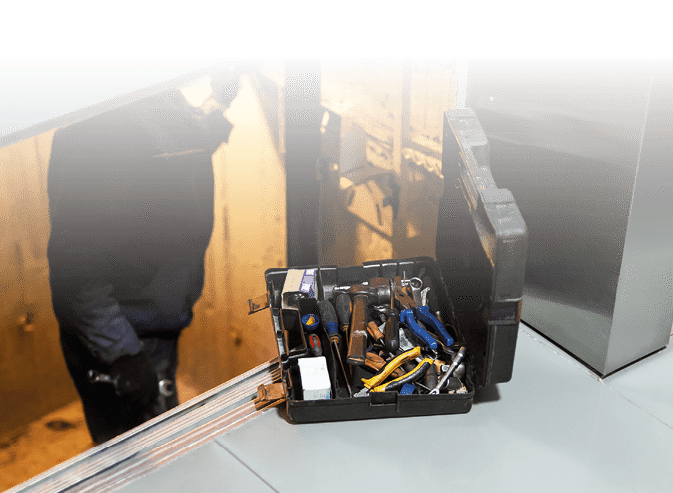 Specialist fixing or adjusting lift mechanism in elevator schaft. Regular repair, service and maintenance of elevator.